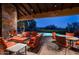 Evening view of pool and patio with fireplace and seating at 10626 E Palo Brea Dr, Scottsdale, AZ 85262