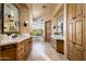 Large bathroom with double vanity and wood cabinets at 10626 E Palo Brea Dr, Scottsdale, AZ 85262