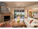 Living room features a stone fireplace, large windows and patio access at 10626 E Palo Brea Dr, Scottsdale, AZ 85262