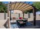 Cozy patio area with pergola, seating, and colorful pillows at 161 N Silverwood Dr, Casa Grande, AZ 85122