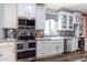 Modern kitchen with white cabinets, a farmhouse sink, and stainless steel appliances at 161 N Silverwood Dr, Casa Grande, AZ 85122
