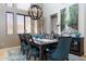 A spacious dining room featuring a dark wood table, teal chairs, and large artwork at 161 N Silverwood Dr, Casa Grande, AZ 85122