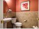 Updated bathroom with tile flooring, pedestal sink, and toilet at 161 N Silverwood Dr, Casa Grande, AZ 85122
