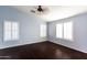 Bright bedroom with dark hardwood floors, ceiling fan, and window shutters at 3513 S 87Th Dr, Tolleson, AZ 85353