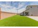 Artificial turf backyard with string lights and a grilling area at 36545 N Herens Rd, San Tan Valley, AZ 85143