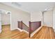 Upstairs hallway with wood flooring and a view into other rooms at 17434 W Madison St, Goodyear, AZ 85338