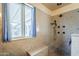 Modern bathroom with walk-in shower, tile walls, and window at 2124 E Osborn Rd, Phoenix, AZ 85016