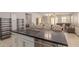 Island kitchen with seating, dark countertops, and a view into the living room at 17986 W Fulton St, Goodyear, AZ 85338