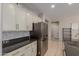 Kitchen features stainless steel refrigerator, white cabinets, and dark countertops at 17986 W Fulton St, Goodyear, AZ 85338
