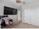Bedroom with large TV, desk and double doors at 17986 W Fulton St, Goodyear, AZ 85338