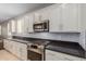 Modern kitchen features white cabinets, dark countertops, and gas cooktop at 17986 W Fulton St, Goodyear, AZ 85338