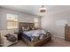 Bright bedroom with a queen bed, chair, and window coverings at 17986 W Fulton St, Goodyear, AZ 85338