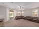 Spacious Gathering room with brown sectional sofa and sliding glass door to backyard at 17986 W Fulton St, Goodyear, AZ 85338