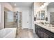 Elegant bathroom with a soaking tub, glass shower, and dark vanity at 4145 S Zephyr --, Mesa, AZ 85212