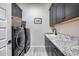Laundry room with dark cabinets, granite countertop, and a washer and dryer at 4145 S Zephyr --, Mesa, AZ 85212