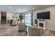 Living room with fireplace, two armchairs, and sliding glass doors leading to the backyard at 6514 N 85Th Pl, Scottsdale, AZ 85250