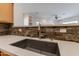 Modern kitchen sink with stone backsplash at 2223 E Branham Ln, Phoenix, AZ 85042