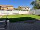 Landscaped backyard with grassy lawn and brick patio at 1232 E Strawberry Dr, Gilbert, AZ 85298