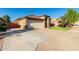 Tan one-story house with a two car garage and manicured lawn at 8752 E Plata Ave, Mesa, AZ 85212