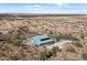 Aerial view of a home with solar panels and a pool, overlooking a vast desert landscape at 13060 N Palomino Rd, Maricopa, AZ 85139