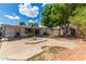 Large backyard with covered patio, fire pit, and mature shade tree at 4628 E Holly St, Phoenix, AZ 85008