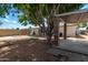 Landscaped backyard with a large tree and a covered patio area at 4628 E Holly St, Phoenix, AZ 85008