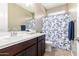 Bathroom with shower/tub combo, double vanity, and floral shower curtain at 37784 W San Sisto Ave, Maricopa, AZ 85138
