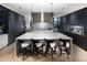 Modern kitchen with dark cabinetry, marble countertops, and island seating at 6850 E Joshua Tree Ln, Paradise Valley, AZ 85253