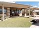 Covered patio with seating area, adjacent to grassy yard at 10683 E Saddle Blanket Trl, Gold Canyon, AZ 85118