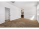 Light-filled bedroom with carpet and access to bathroom at 16887 W Alice Ave, Waddell, AZ 85355