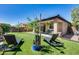 Artificial turf backyard with lounge chairs and trees at 4707 S Avitus Ln, Mesa, AZ 85212