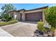 Single story home with a brown garage door and landscaping at 4707 S Avitus Ln, Mesa, AZ 85212