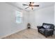Spacious bedroom with ceiling fan, window, and comfortable chair at 4707 S Avitus Ln, Mesa, AZ 85212