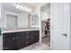 Bathroom with double vanity, large mirror, and walk-in closet at 4707 S Avitus Ln, Mesa, AZ 85212