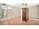 Simple bedroom with wood-look floors, ceiling fan, and large wardrobe at 12807 W Mesa Verde Dr, Sun City West, AZ 85375