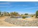Community pond with rock retaining wall and homes nearby at 18364 N Diamond Dr, Surprise, AZ 85374