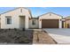 Modern home's front exterior with two-car garage and desert landscaping at 37735 W Padilla St, Maricopa, AZ 85138