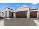 Two-car garage and front elevation of a modern home with desert landscaping at 37735 W Padilla St, Maricopa, AZ 85138