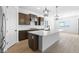 Modern kitchen with island, stainless steel appliances, and dark wood cabinets at 37735 W Padilla St, Maricopa, AZ 85138