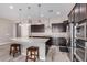 Modern kitchen with dark wood cabinets, granite island, and stainless appliances at 23142 E Thornton Rd, Queen Creek, AZ 85142