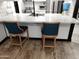 Kitchen island with marble countertop and two blue barstools at 3119 W Cochise Dr # 225, Phoenix, AZ 85051