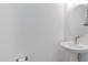 Simple bathroom with pedestal sink, oval mirror, and white walls at 10763 W Beatrice St, Avondale, AZ 85323