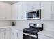 Stainless steel range and microwave in a kitchen with white cabinets at 10763 W Beatrice St, Avondale, AZ 85323