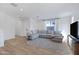 Spacious living room with L-shaped sofa, large TV, and wood-look floors at 10763 W Beatrice St, Avondale, AZ 85323