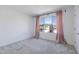 Well-lit bedroom with large window, pink curtains, and neutral carpeting at 10763 W Beatrice St, Avondale, AZ 85323