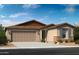 Single-story home with a two-car garage and desert landscaping at 36503 W San Ildefanso Ave, Maricopa, AZ 85138