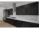 Modern kitchen with dark cabinetry and quartz countertops at 17279 W Dartmouth St, Surprise, AZ 85388