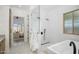 Bright bathroom with walk-in shower, soaking tub, and backyard view at 2144 E San Juan Ave, Phoenix, AZ 85016