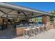 Outdoor kitchen and dining area with seating and grills at 18226 W Desert Willow Dr, Goodyear, AZ 85338