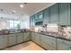 Modern kitchen featuring light green cabinets and stone backsplash at 2211 E Camelback Rd # 505, Phoenix, AZ 85016
